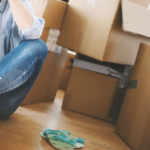 A girl sitting on the floor surrounded by boxes